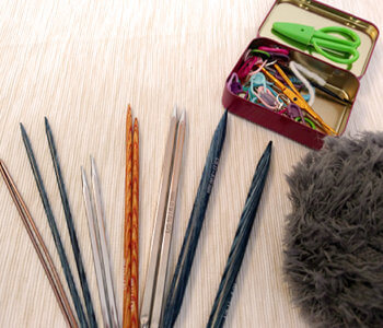 A variety of knitting needles, notions, and alpaca fur yarn
