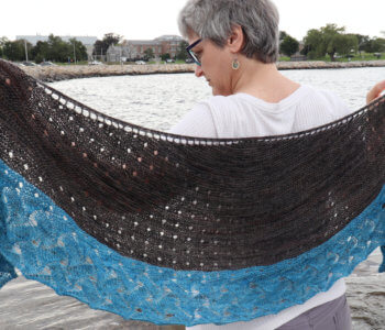 Ocean Home Shawl by Brenda Schack is a knitting pattern for a top down crescent shawl that features a water like lace for a bottom border