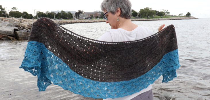 Ocean Home Shawl by Brenda Schack is a knitting pattern for a top down crescent shawl that features a water like lace for a bottom border